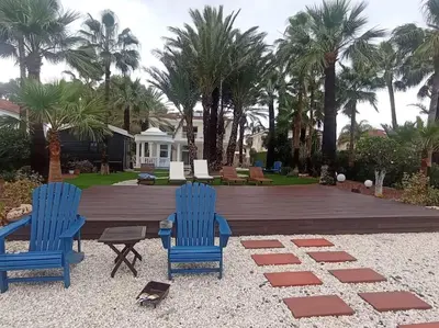 two blue chairs and a table and some palm trees at Beachfront villa Meneou in Meneou