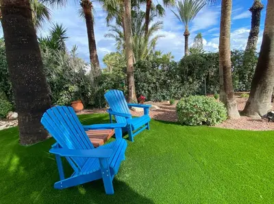 two blue chairs sitting on a lawn with palm trees at Beachfront villa Meneou in Meneou