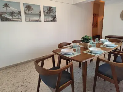 a dining room with a wooden table and chairs at Marina view seaside apartment in Larnaka