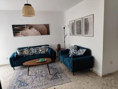 a living room with two blue couches and a table at Marina view seaside apartment in Larnaka