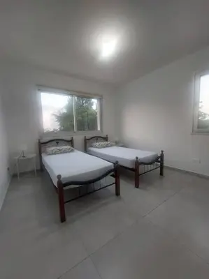 two beds in a white room with two windows at Luxury 2 bedroom apartment in Larnaka