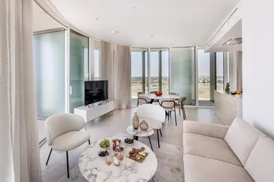 a living room with white furniture and glass windows at Ayia Napa Marina East Tower Suite in Ayia Napa