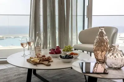 a table with a plate of food and glasses of wine at Ayia Napa Marina East Tower Suite in Ayia Napa