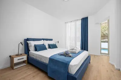 a bedroom with a blue and white bed and a window at Paradise Apartment with Private Pool & Sea View in Larnaka