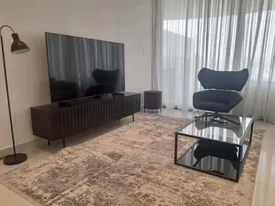 a living room with a flat screen tv and a chair at 360 Building - City View 2 Bedroom Residence in Nicosia