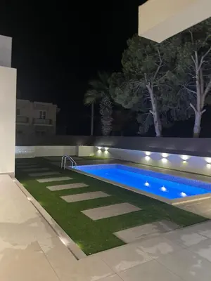 a swimming pool in a backyard at night at Pervolia Oasis Villa in Kiti