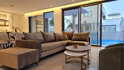 a living room with a couch and tables and windows at STAY Oasis Luxury Villas in Ayia Napa