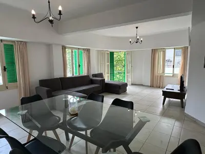 a living room with a glass table and chairs at city center accommodation in Nicosia