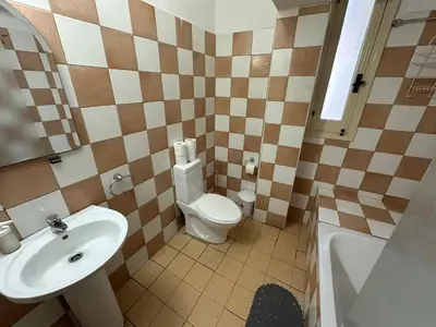 a small bathroom with a toilet and a sink at city center accommodation in Nicosia