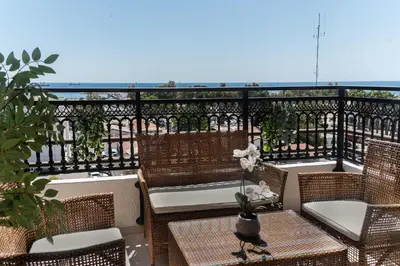 a balcony with wicker chairs and tables on a balcony at Phaedrus Living Seaview Phinikoudes Flat in Larnaka