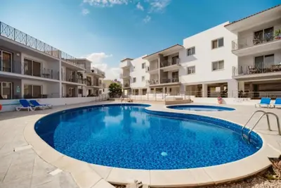 a swimming pool in the middle of a courtyard with apartment buildings at Apartment Veronika in Paralimni