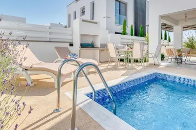 a patio with a swimming pool next to a house at Luxurious Villa Alasia in Paralimni in Paralimni