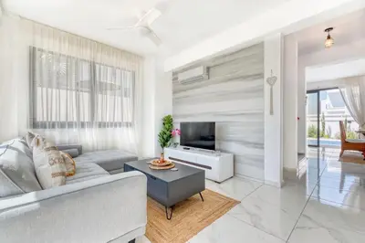 a living room with a couch and a tv at Luxurious Villa Alasia in Paralimni in Paralimni