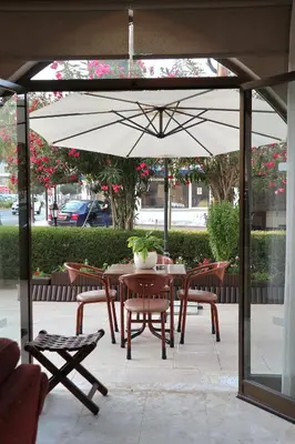 a table and chairs under an umbrella on a patio at Layiotis Hotel in Larnaka
