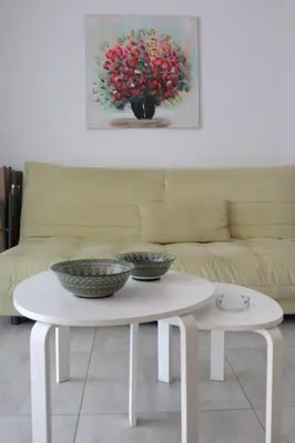 a white coffee table with three bowls on it in front of a couch at Layiotis Hotel in Larnaka