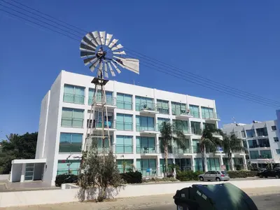 a building with a windmill in front of it at Luxary Vacation by the Sea Protaras in Protaras