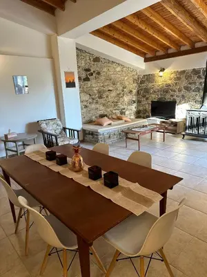 a dining room with a wooden table and chairs at Loucy’s Art Home in Mandria