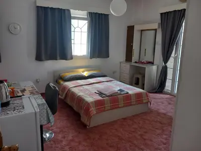a bedroom with a bed and a dresser and a mirror at Vasilis family room in Mor Menekshe