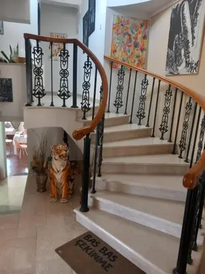 a dog sitting under the stairs in a house at Vasilis family room in Mor Menekshe