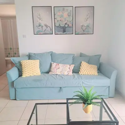 a blue couch in a living room with a glass table at CyPresa Sweet Home Oroklini in Larnaka