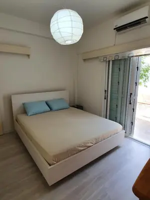 a bedroom with a large bed with blue pillows at The Little House in Voroklini