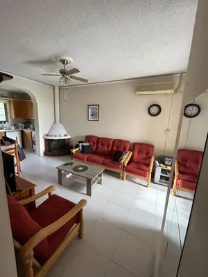 a living room with a red couch and a table at Kuća za odmor Kipar in Pissouri
