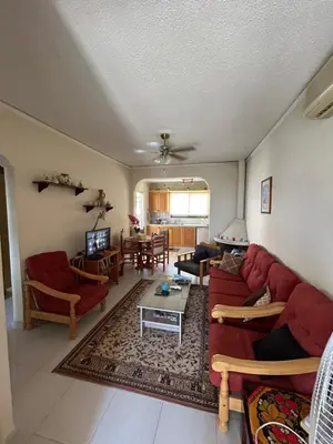 a living room with a red couch and a table at Kuća za odmor Kipar in Pissouri