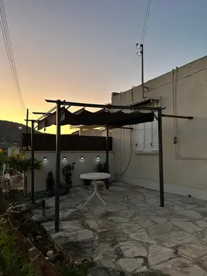 a patio with a picnic table under a canopy at Kuća za odmor Kipar in Pissouri