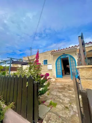 a house with a blue door and a fence at Kuća za odmor Kipar in Pissouri