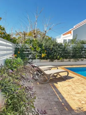a bench sitting on a patio next to a swimming pool at Hephaestus Family Villa, Ayia Triada Beach in Paralimni