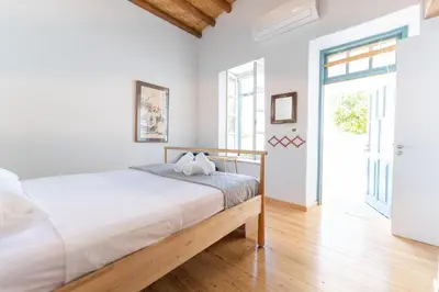 a white bedroom with a bed and a door at 1927 Heritage House - Indoor Garden , Old City in Nicosia