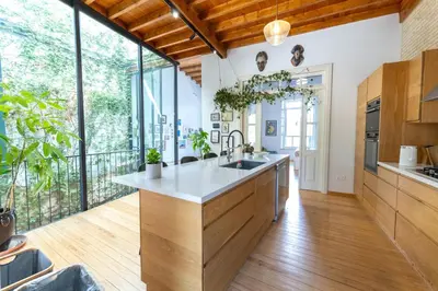 a kitchen with wooden cabinets and a large window at 1927 Heritage House - Indoor Garden , Old City in Nicosia