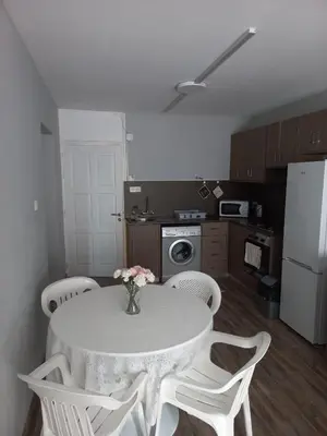 a kitchen with a table with white chairs and a white refrigerator at Oroklini, Cyprus in Voroklini