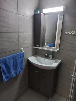 a bathroom with a sink and a mirror and blue towel at Oroklini, Cyprus in Voroklini