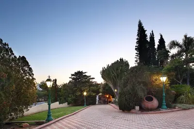 a cobblestone street with two street lights and trees at Olive Tree Apartments in Limassol
