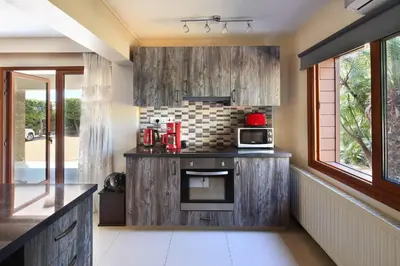 a kitchen with wooden cabinets and a microwave oven at Olive Tree Apartments in Limassol