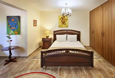 a bedroom with a large bed and a table at Olive Tree Apartments in Limassol