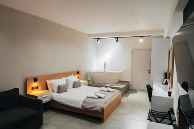 a bedroom with a bed and a bath tub in it at Kition Urban Suite 1 in Larnaka