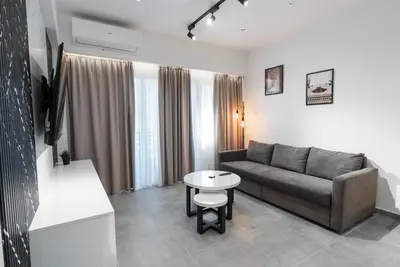 a living room with a couch and a table at Kition Urban Suite 1 in Larnaka