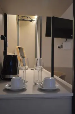 a table with two cups and two wine glasses at LEONDIANA Boutique Hotel in Larnaka