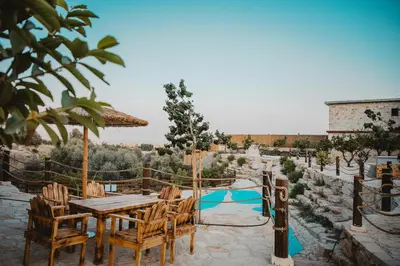 a patio with a table and chairs and a pool at Kleos Noble Retreat - Private Estate in Limassol