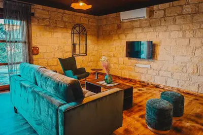 a living room with a blue couch and a brick wall at Kleos Noble Retreat - Private Estate in Limassol