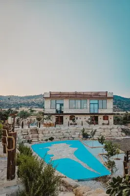 a house with a blue pool in front of it at Kleos Noble Retreat - Private Estate in Limassol