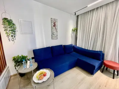 a living room with a blue couch and a table at SuiteNapa22 in Ayia Napa