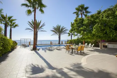 a patio with a table and chairs and the ocean at Luxury Villa With Special Sea Views in Meneou