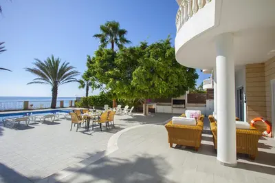 a patio with a table and chairs and the ocean at Luxury Villa With Special Sea Views in Meneou