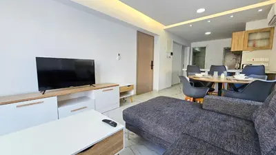 a living room with a couch and a table with chairs at Urban Comfort Apartment in Larnaka