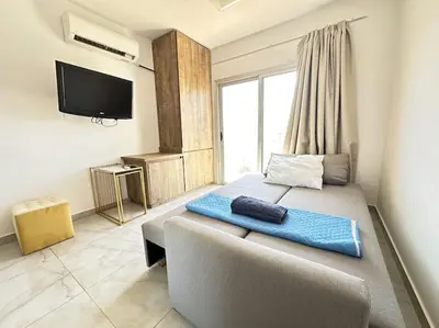 a bedroom with a large bed with a large window at Alice Studio Holiday Apartment - Ayia Napa in Ayia Napa