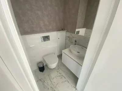 a white bathroom with a sink and a toilet at The Address -Beachfront 2 Bedroom Residence in Limassol