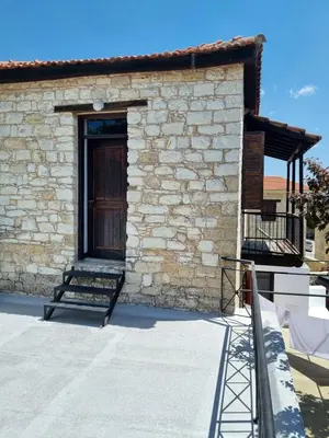 a brick building with a wooden door and a porch at Villa Christothea in Paphos